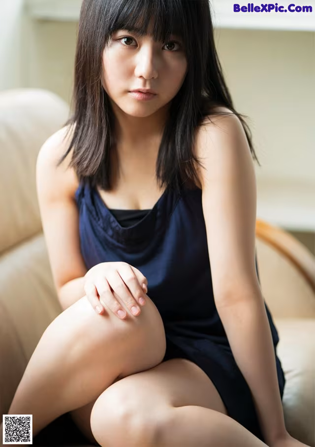 A woman sitting on a couch with her legs crossed.