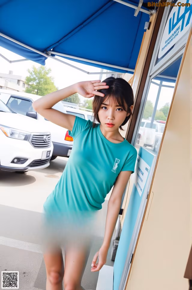 A woman in a green shirt and striped shorts posing for a picture.