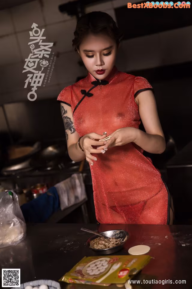 A woman in a red dress preparing food in a kitchen.