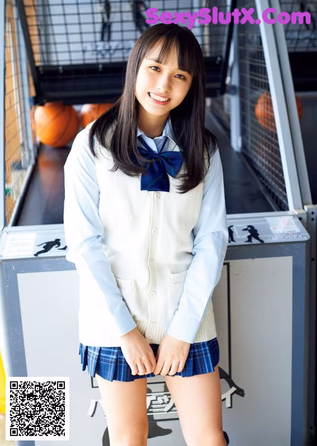 A young woman in a school uniform posing for a picture.
