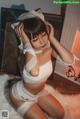 A woman in a white lingerie sitting on a white rug.