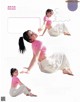 A woman in a pink shirt and white pants is doing yoga.