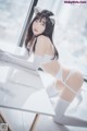 A woman in a white lingerie sitting at a table.