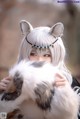 A woman with white hair holding a fluffy white cat.