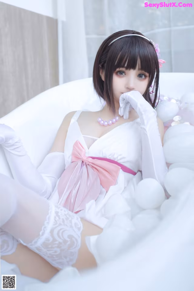 A woman in a white dress sitting in a bathtub.